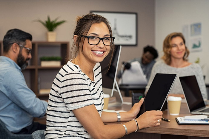 Woman sitting at desk, smiling at camera