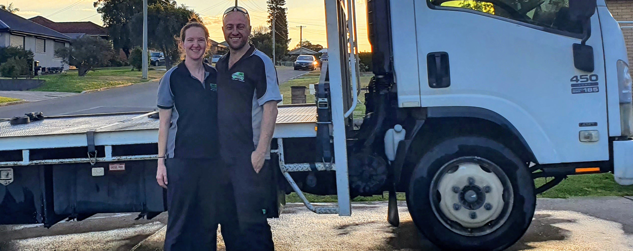Amanda and her employer standing inf front of a truck