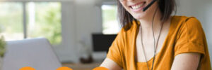 young woman with headset working on laptop