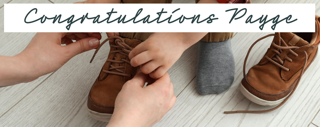 hands helping child to do up shoelaces