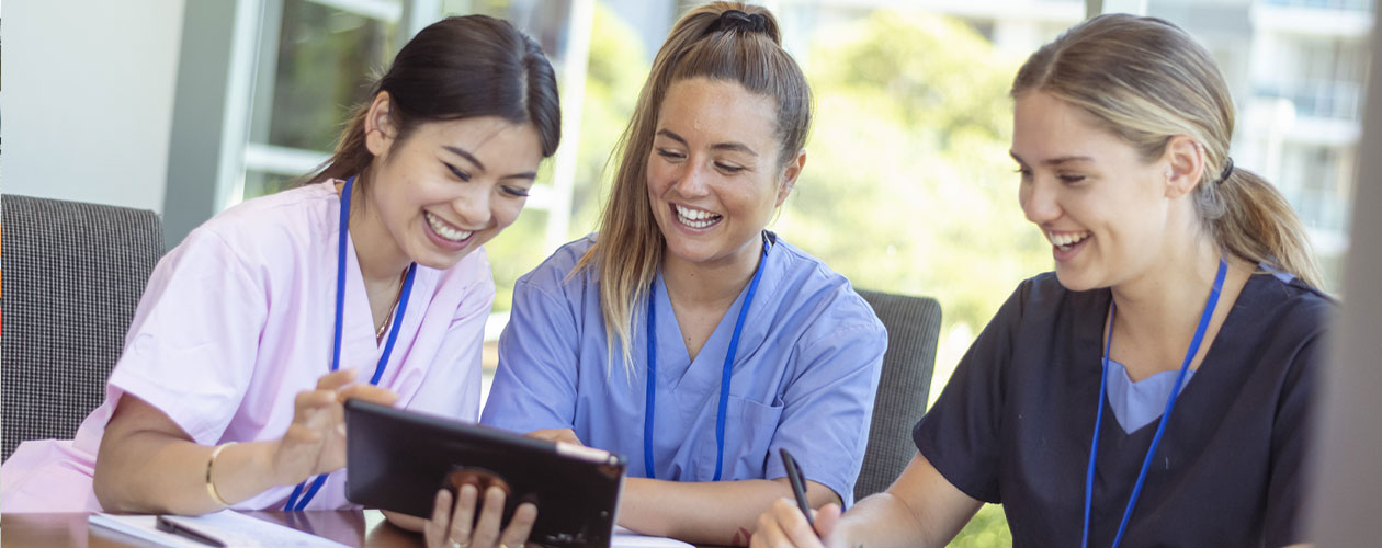 3 support staff looking at ipad