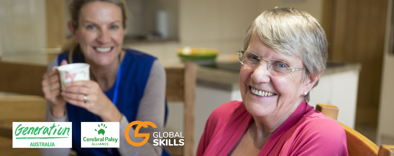 older person sitting at table with her support worker