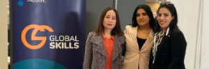Global Skills staff standing next to the banner in our stall