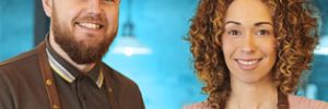 A man and woman with cafe light and shelves in background