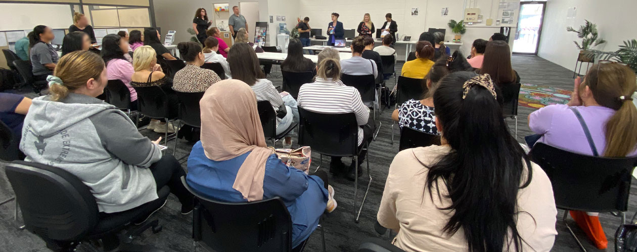 women sitting on chairs listening to employers presentation