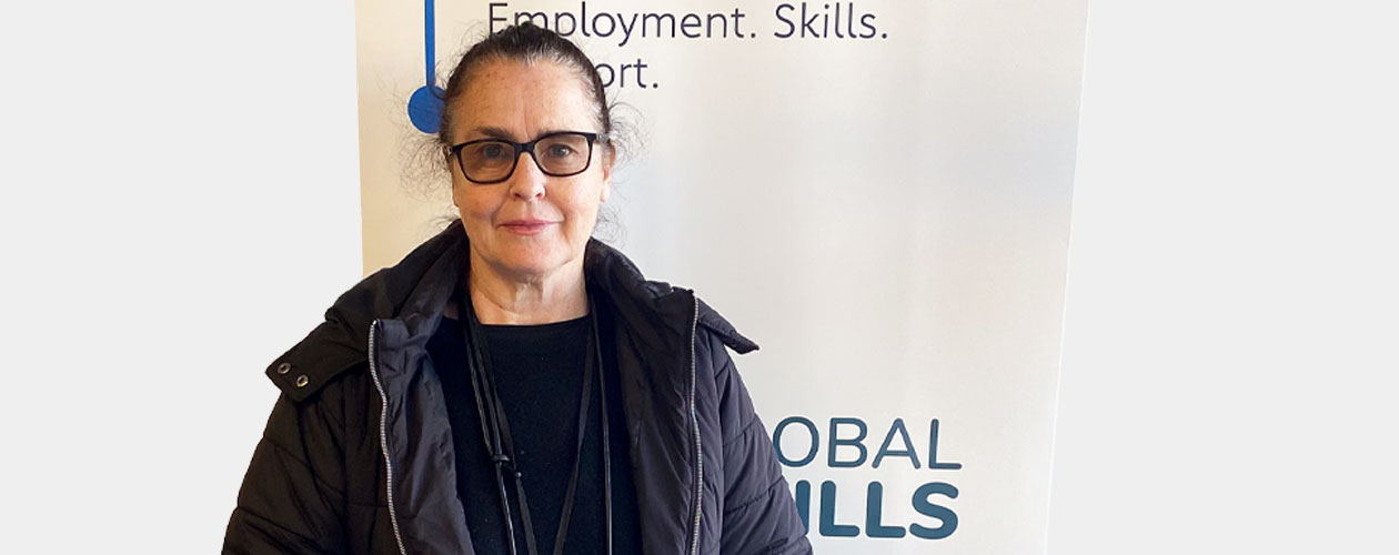 Picture of Cate standing in front of our Workforce Australia banner