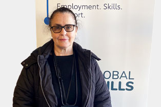 Picture of Cate standing in front of our Workforce Australia banner