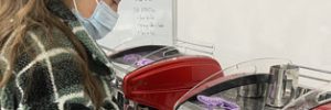 a student using a red coffee machine to make coffee