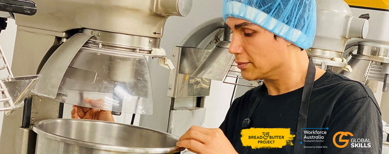 Javid, wearing a hairnet and looking into a large mixing bowl