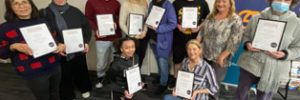 graduates holding their certificates