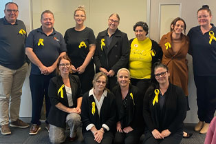 Group photo of our Lake Haven staff all with yellow ribbons attached to their clothing
