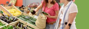 Woman with crutches receiving support to buy fresh produce
