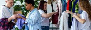 4 people sorting and hanging donated clothes