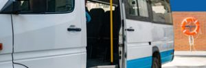A white van with a blue stripe, parked with its door open, and a lifesaving ring visible in the background
