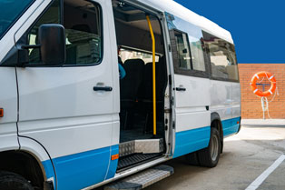 A white van with a blue stripe, parked with its door open, and a lifesaving ring visible in the background