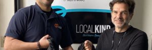 Robby and Daniel standing in front of LocalKinds banner. They are each holding some of the bags.