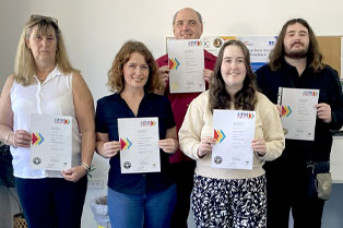 Graduates holding their certificates