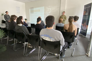 Participants seated, attentively listening to the presentation by Australian Defence Force personnel