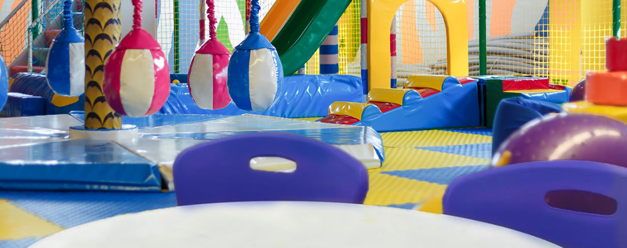 A cafe table and chairs with play equipment in the background