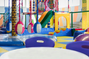 A cafe table and chairs with play equipment in the background