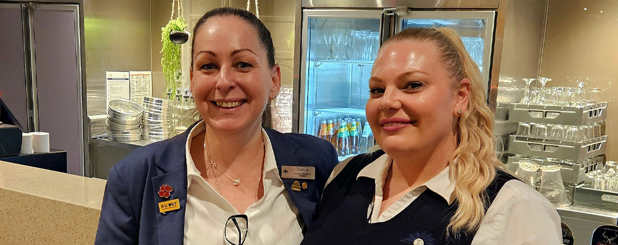 Tianna and Dianne smiling together in front of a bar at the club