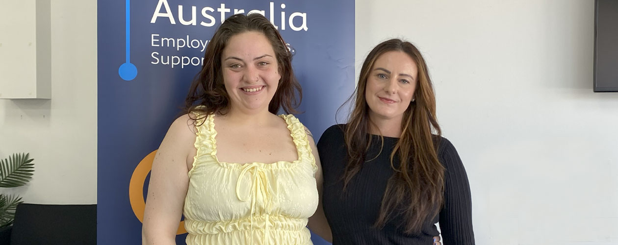 Alanah and Zoe standing in front of a Global Skills banner.