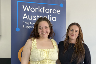 Alanah and Zoe standing in front of a Global Skills banner.