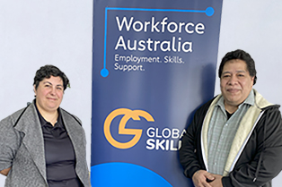 Enimoa and Vanessa standing on either side of a Global Skills banner that reads "Workforce Australia: Employment. Skills. Support." The banner includes the Global Skills logo and website.