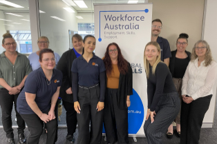 Staff standing in front of Global Skills WFA banner