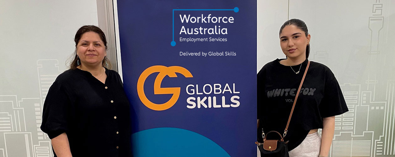 Azita and Mariam standing on either side of a Global Skills banner that reads "Workforce Australia: Employment. Skills. Support." The banner includes the Global Skills logo and website.