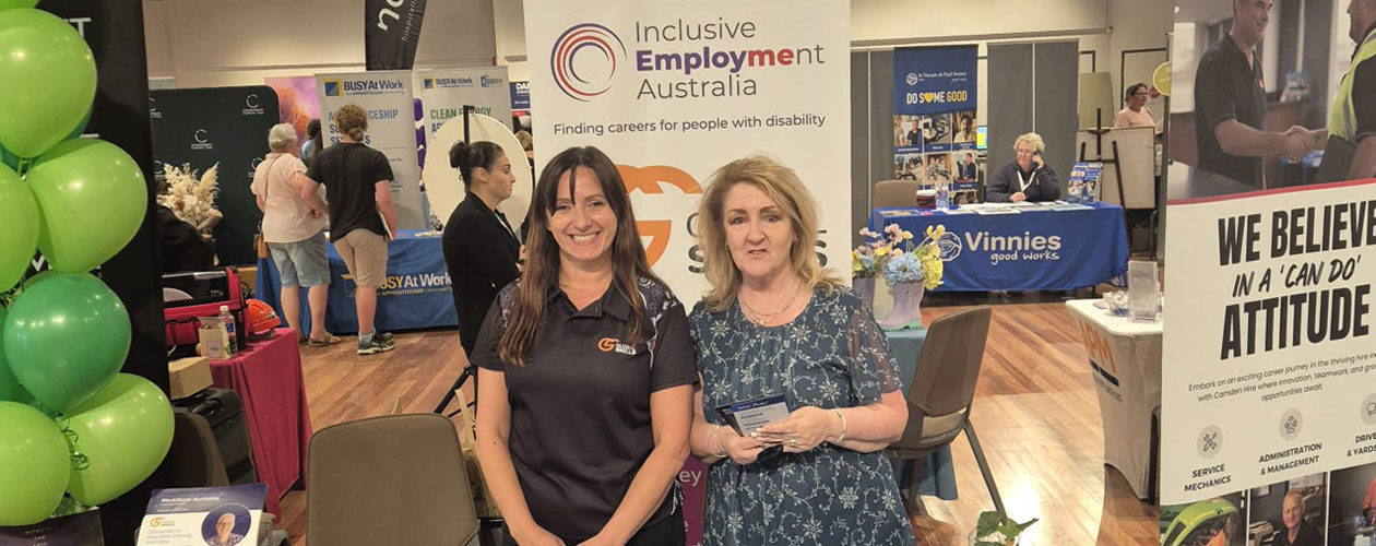 Global Skills team, Nancy and Kim, standing in front of Global Skills’ Inclusive Employment Australia banner at the Expo