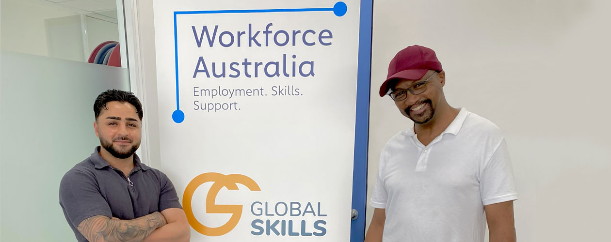 Youssef and Colin standing either side of Global Skills’ Workforce Australia banner at Global Skills Fairfield.