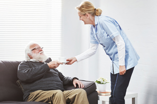 A caregiver offers a cup and saucer to an elderly man seated on a lounge. Workforce Australia and Global Skills logos at bottom left.
