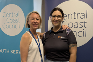 Renee and Chloe smiling and standing in front of Central Coast Council banners.