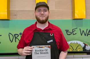 Kyan standing outside McDonalds holding his rookie of the year certifcate