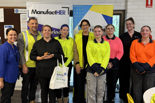 A group photo featuring representatives from CCGT and BAC Australia alongside Global Skills participants, standing in front of ManufactHER and CCGT banners.