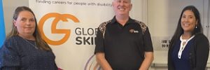 Rachael, Simon and Alyce standing in infront of Global Skills’ Inclusive Employment Australia banner.