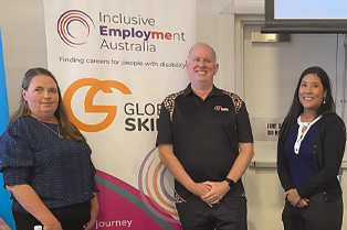 Rachael, Simon and Alyce standing in infront of Global Skills’ Inclusive Employment Australia banner.