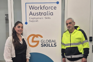 Natasha and Raad standing either side of a Global Skills Workforce Australia banner. Raad is wearing high-visibility workwear.