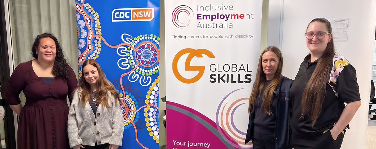 Global Skills CTA Trainer Inareta and Executive Manager Elizabeth with CDC NSW Recruitment Specialists Amanda and Jacqueline beside CDC NSW and Global Skills Inclusive Employment Australia banners.