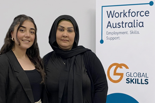 Bushra and Wasan standing in front of Global Skills’ Workforce Australia banner.