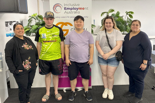 Young people and staff stand together in front of a Global Skills and Inclusive Employment Australia banner at the Mount Druitt Youth Advisory Group session.